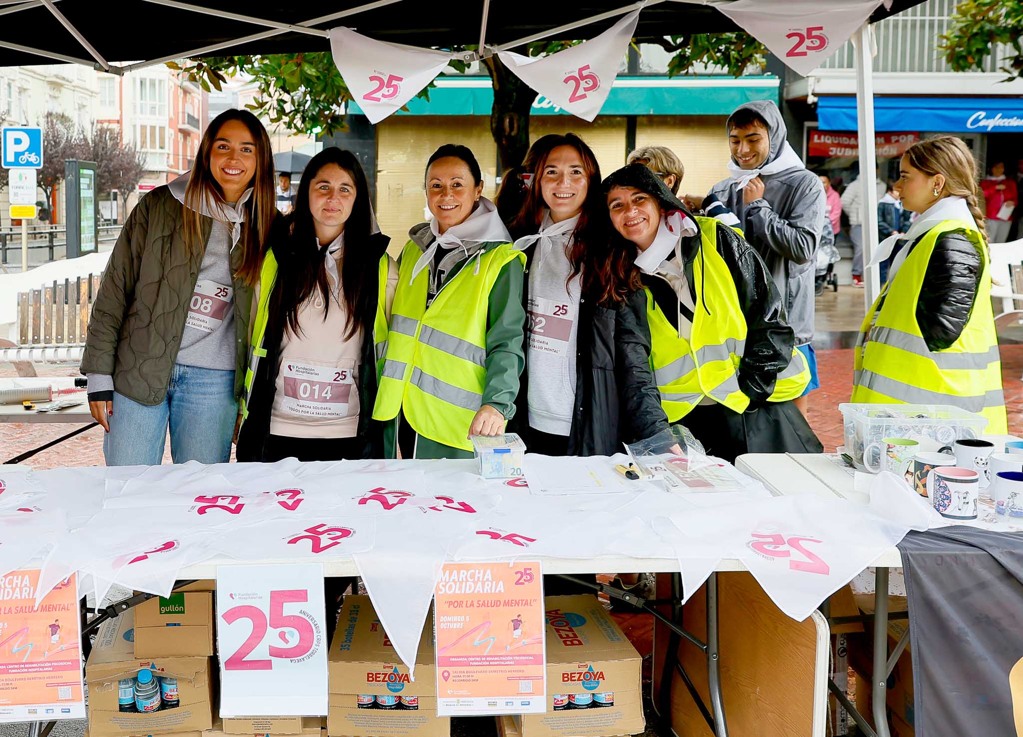 Integrantes y voluntarias posan en el puesto de la organización. 