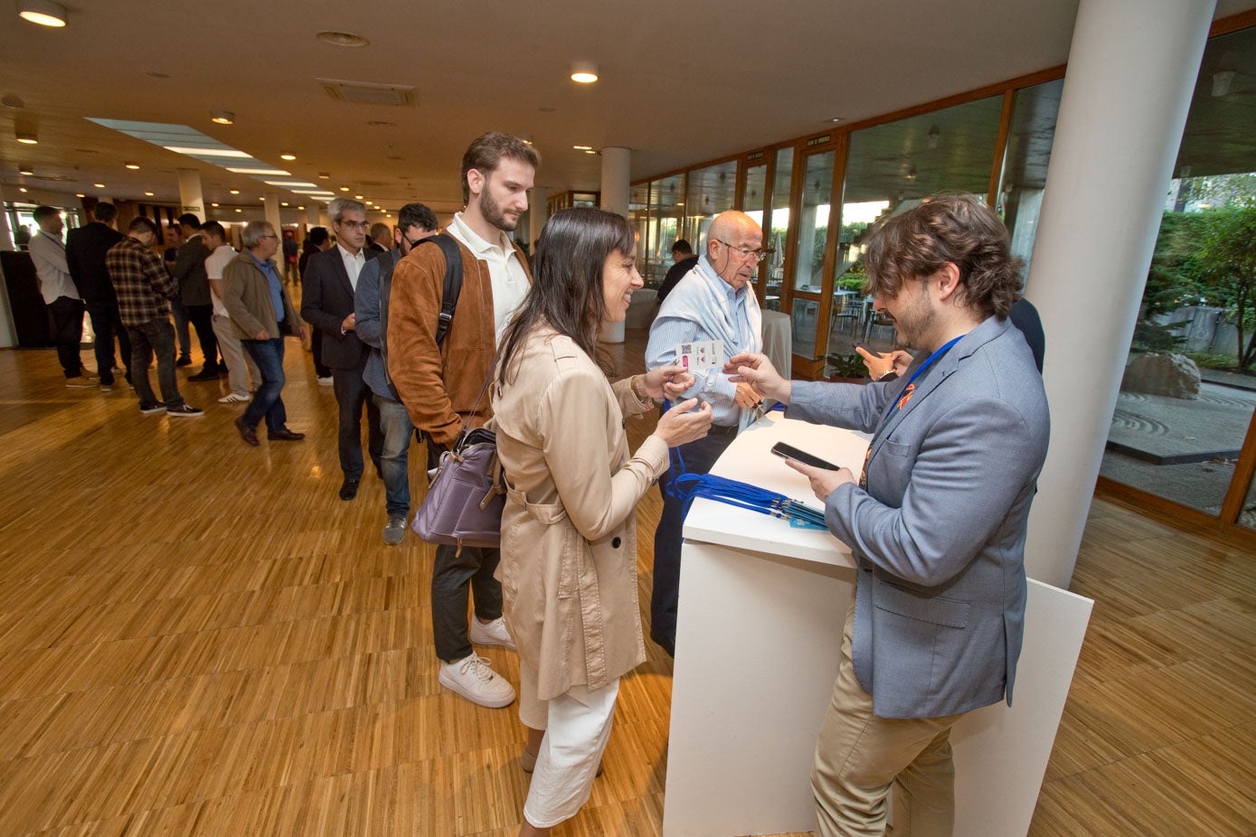 Los asistentes al congreso hacen cola para recoger sus acreditaciones.
