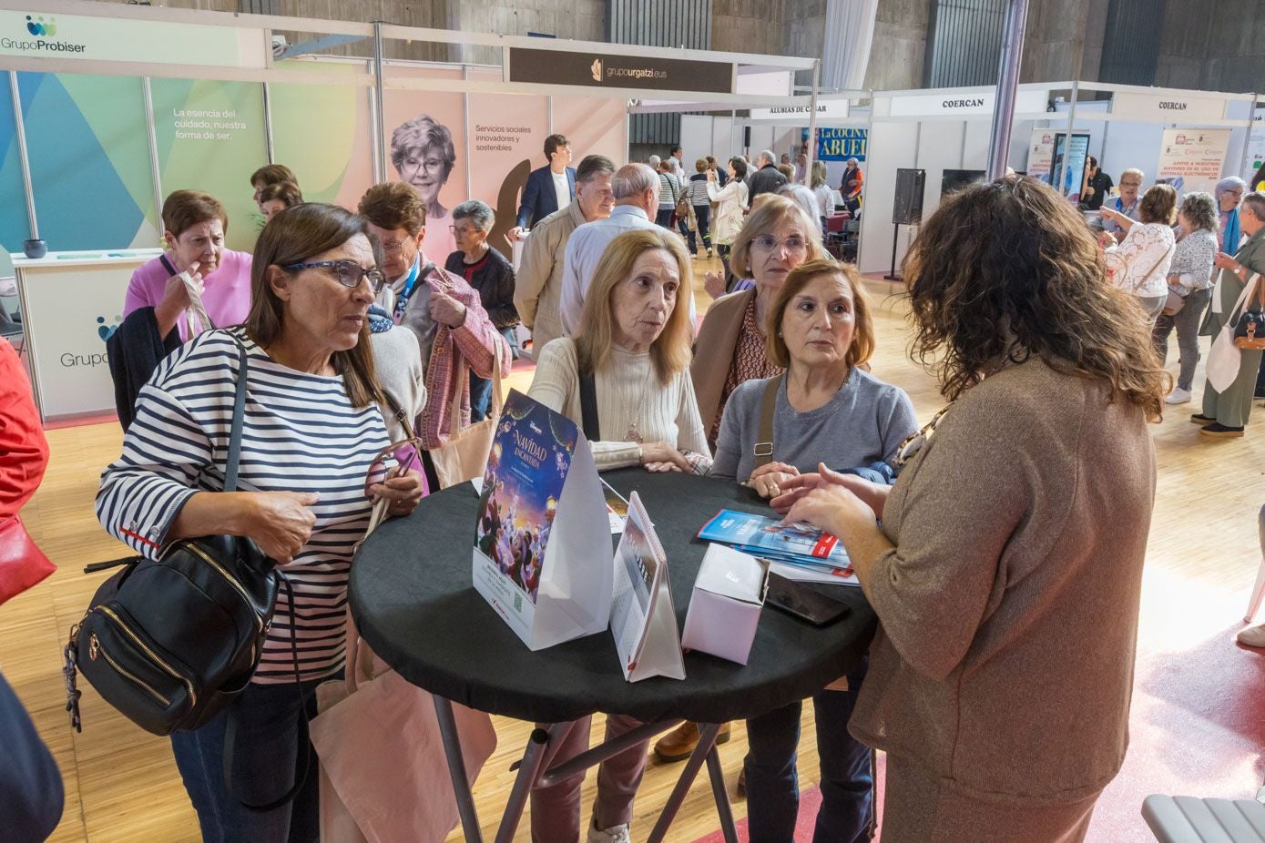 Asistentes a la feria se informan en un stand sobre cómo poder planficar sus vacaciones.