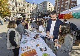 Guillermo Setién y Miriam Rodríguez atienden a los asistentes en el puesto de Ascasam en la plaza del Ayuntamiento de Santander.