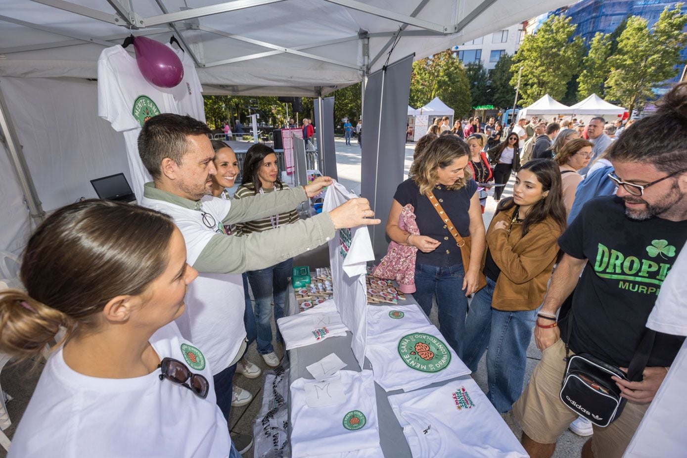Asistentes comprando camisetas para recaudar dinero para las asociaciones.
