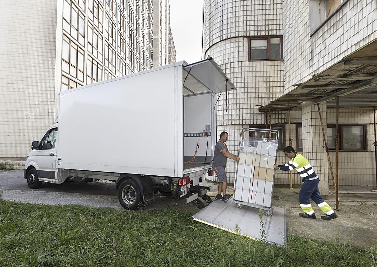Imagen secundaria 1 - A la izquierda, momento en el que cargan en un camión las cajas de documentación retiradas, con la Residencia de fondo. A la derecha, varios operarios continúan con el vaciado de la planta baja. 