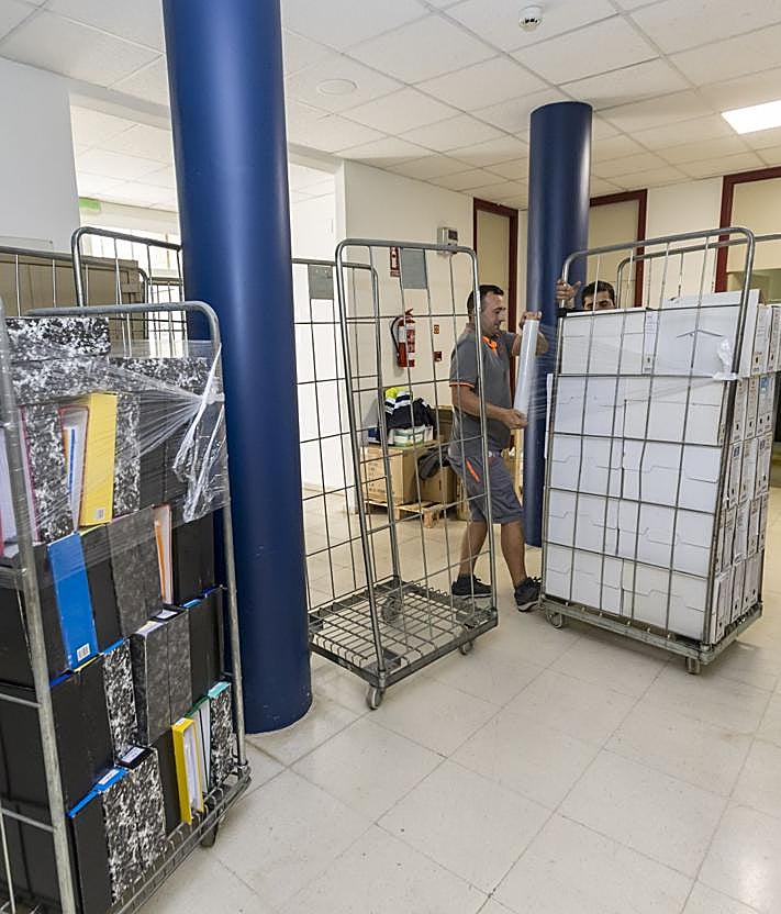 Imagen secundaria 2 - A la izquierda, momento en el que cargan en un camión las cajas de documentación retiradas, con la Residencia de fondo. A la derecha, varios operarios continúan con el vaciado de la planta baja. 