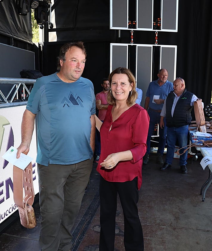 Imagen secundaria 2 - Entrada de ganado al recinto de la feria en Camasleño y Carmen Fernández, entregando uno de los premios a un ganadero de Los Llanos