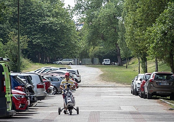 Un hombre porta sus palos de golf por la zona de Mataleñas que se arreglará.