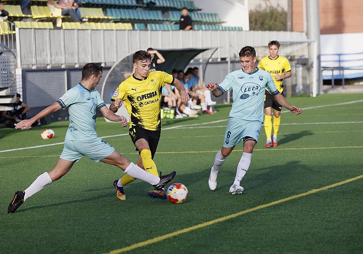 Gómez y Hugo luchan por el balón con Cobo, del Bezana.