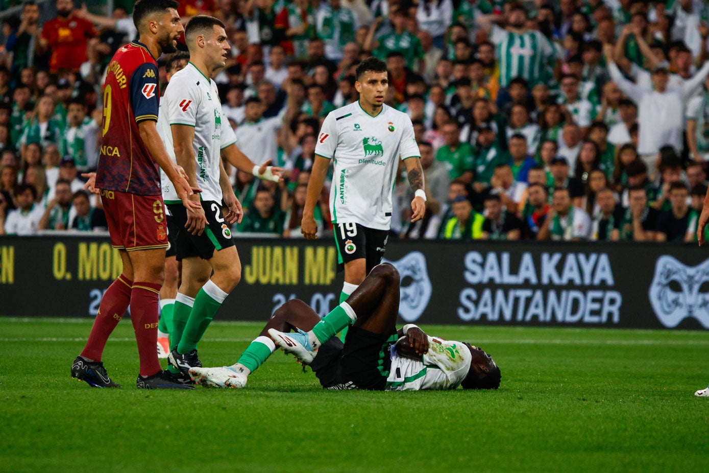 Maguette se duele en el suelo mientras Gustavo Puerta y Álvaro Mantilla acuden a interesarse.