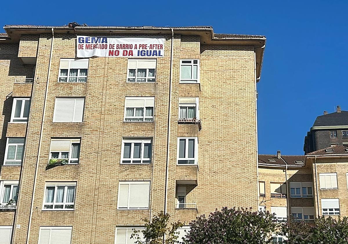 Un hombre en el tejado coloca el cartel que critica la actuación del Ayuntamiento.