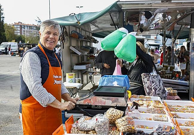 Luis Maestro posa junto a su puesto repleto de dulces y frutos secos.