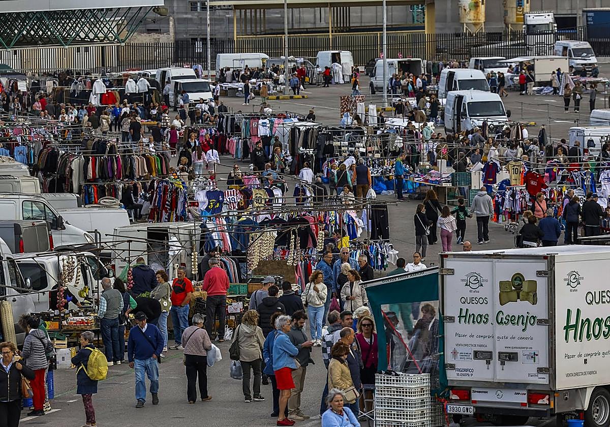 Decenas de personas ojean, compran y caminan por el aparcamiento del Ferial de Torrelavega, ayer, durante el mercado de los jueves.