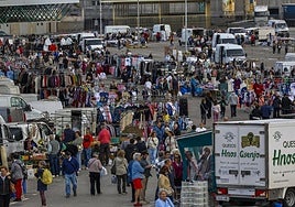 Decenas de personas ojean, compran y caminan por el aparcamiento del Ferial de Torrelavega, ayer, durante el mercado de los jueves.
