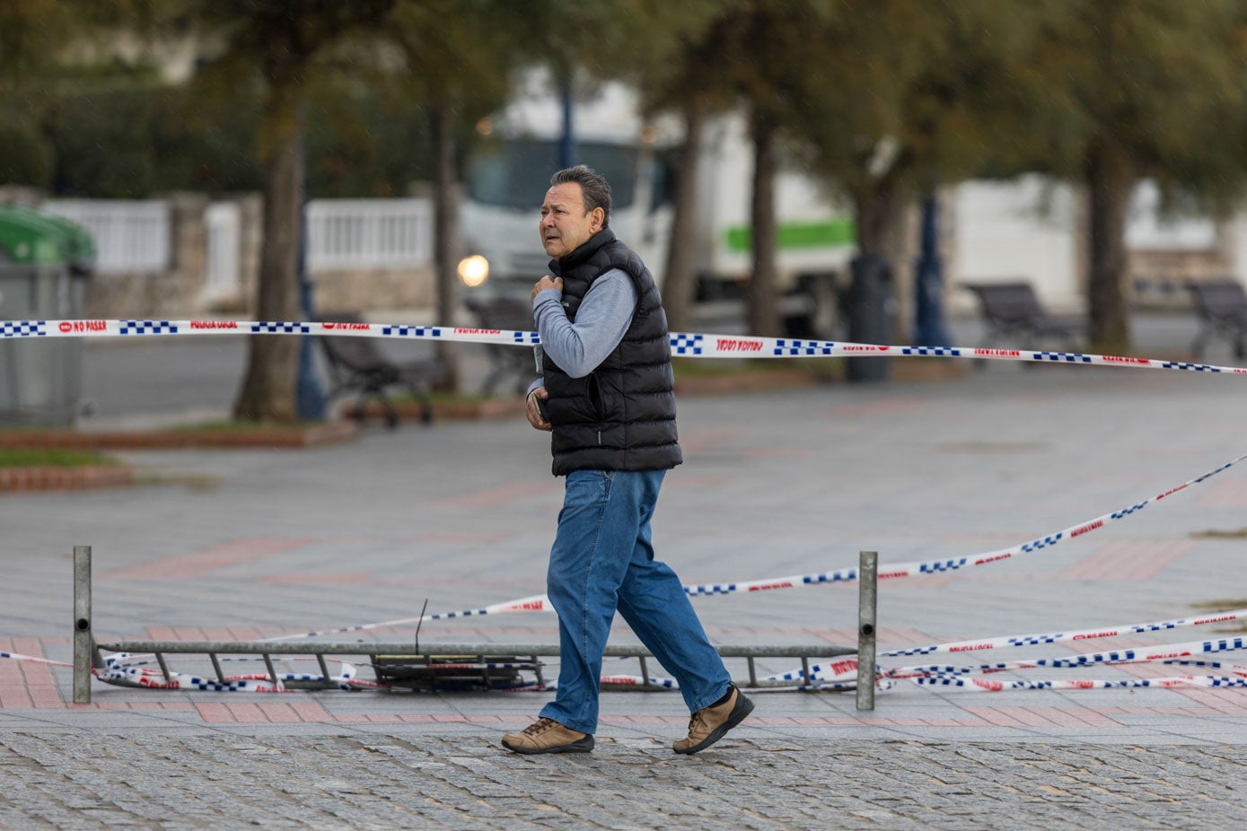 Un hombre pasea por la zona de El Sardinero soportando una fuerte racha de viento.