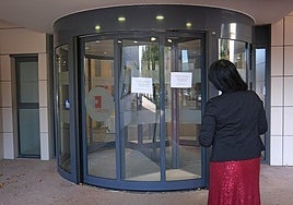 Una vecina se dirige a la puerta giratoria estropeada.