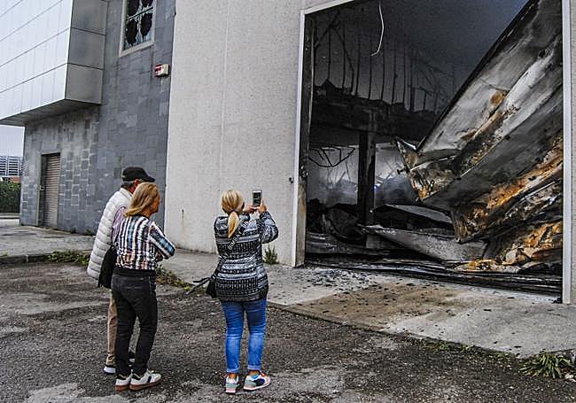 Unos vecinos miran los destrozos y sacan fotos