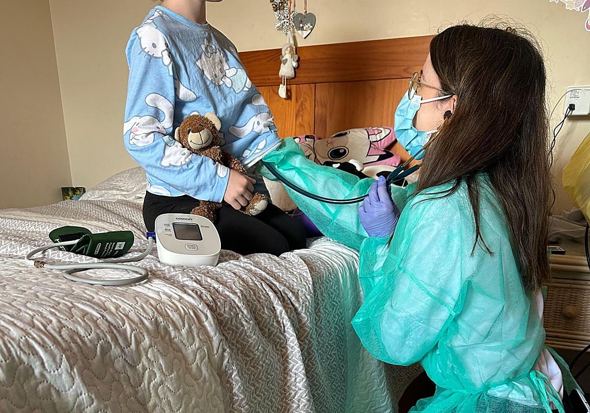 La pediatra Alejandra Coccolo examina a una niña hospitalizada en casa.