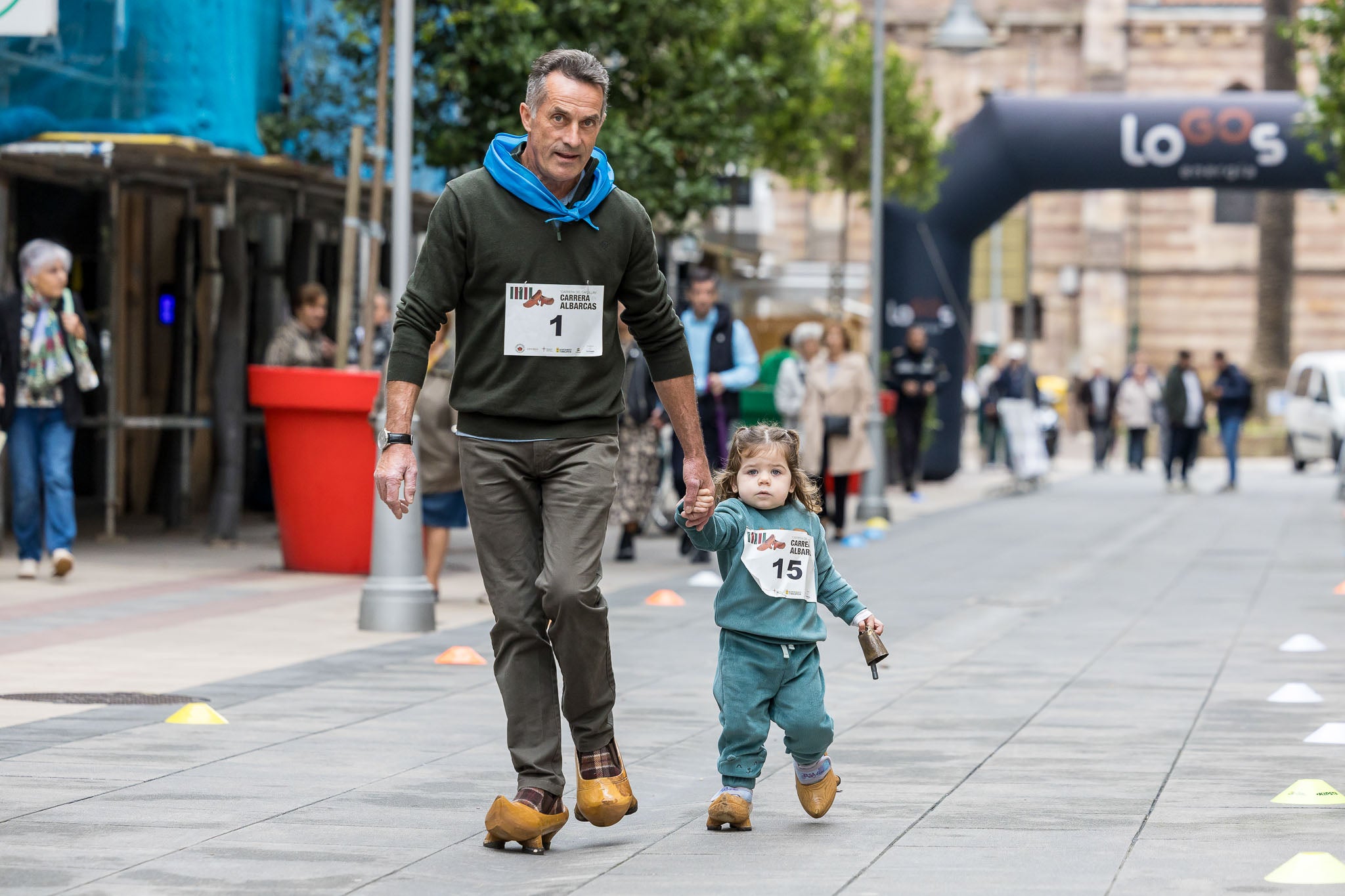 Telva Fernández, con solo dos años, puede presumir de ser la participante más joven de este sábado en la carrera de albarcas; en la foto, avanza junto a su abuelo, Manuel Antonio Fernández, por la calle Consolación.