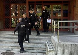 Agentes de la Policía Nacional custodian al detenido a la salida del juzgado de Mieres.