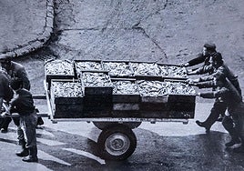 Un grupo de operarios empuja un carro con bocartes para la conservera