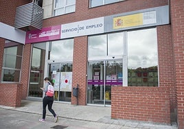 Una mujer camina delante de una oficina del Emcan.