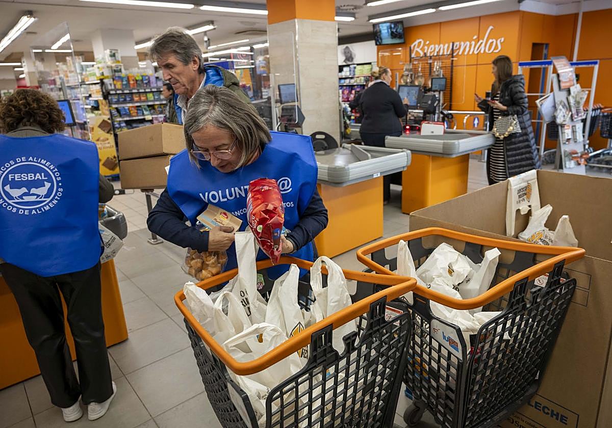 Los voluntarios organizan los productos recibidos en un supermercado durante la Gran Recogida organizada por el Banco de Alimentos de Cantabria.