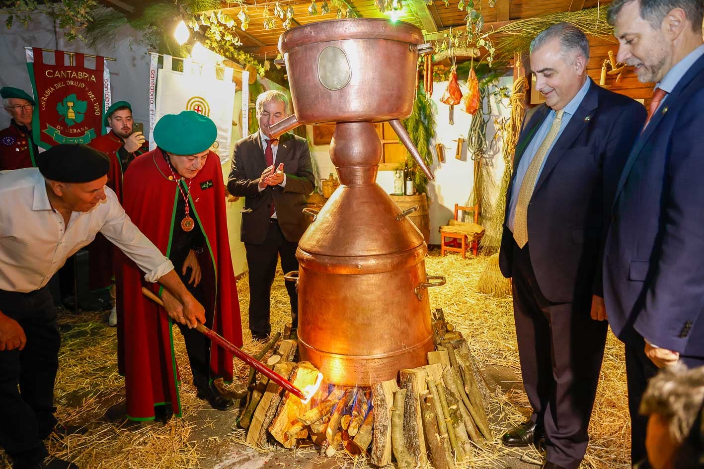 Ribagorda observa cómo encienden una alquitara en presencia del alcalde de Potes y los consejeros de Fomento y Turismo.