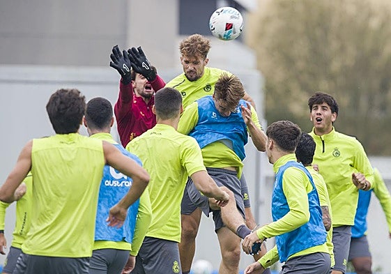 Jokin Ezkieta se dispone a despejar ante el intento de remate de Pablo Ramón en un entrenamiento del Racing en La Albericia.