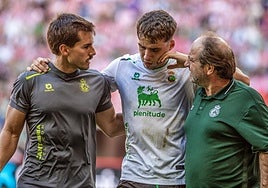 Jorge Salinas, en el momento de abandonar lesionado El Molinón-Enrique Castro 'Quini'.