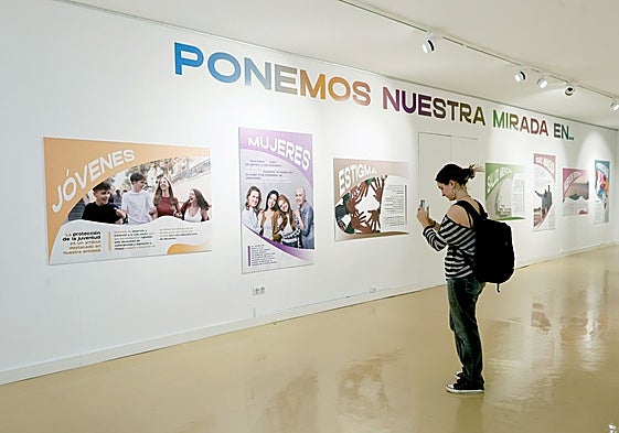 Una joven inmortaliza uno de los carteles de la exposición.