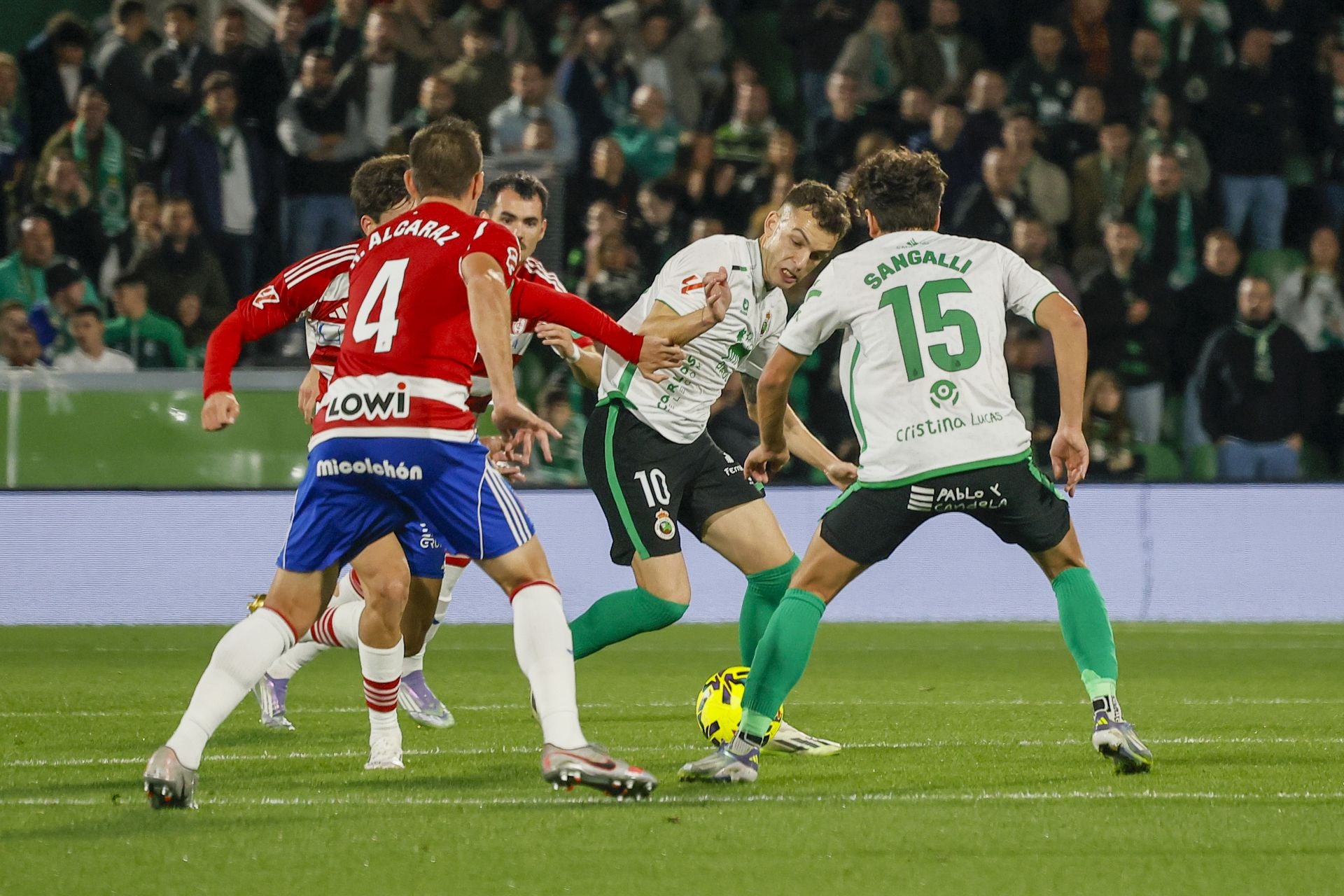 Vicente, con el balón, se revuelve ante dos rivales del Granada apoyado por Sangalli, de espaldas