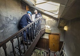 Unos operarios limpian el inmueble afectado por el incendio en el número 33 de Juan de la Cosa.