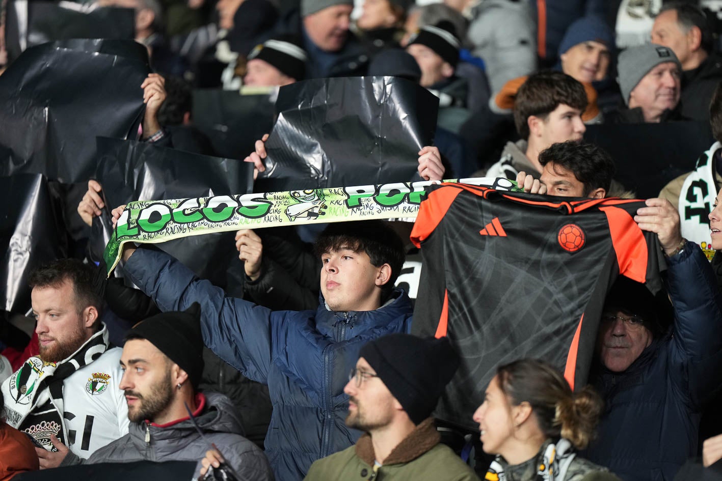 Un aficionado racinguista, rodeado de hinchas locales.