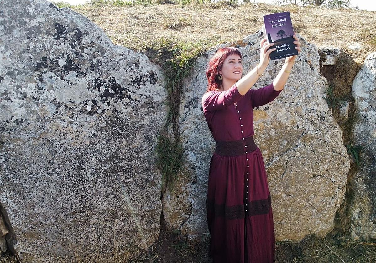 Elisa Ribero Bañuelos portando su tercera novela en la que se cuenta la historia del descubrimiento de la estela y todo lo que ello desató después, junto al nacimiento del colectivo Tribus del Íber.