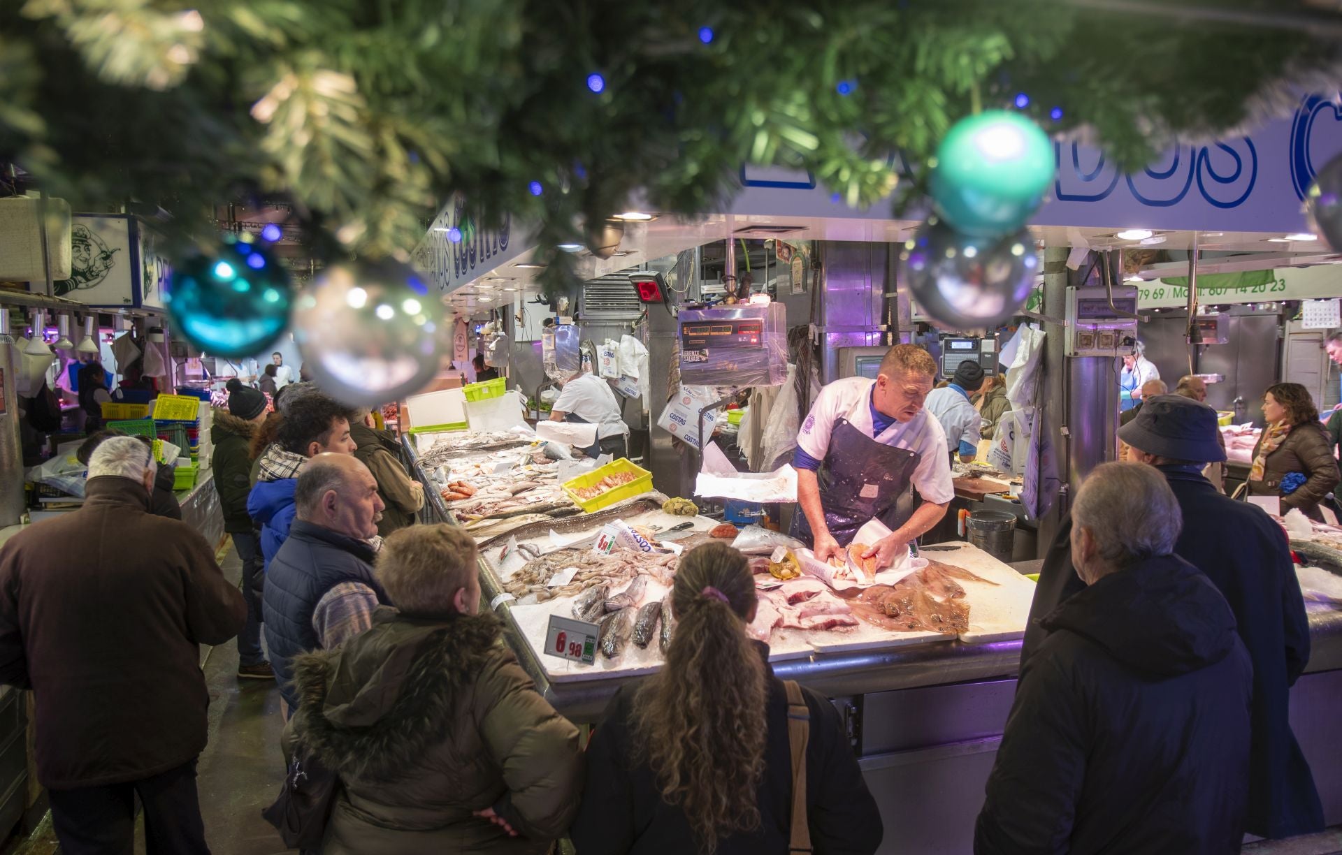 Varios clientes, ayer, esperan para ser atendidos en una de las pescaderías del Mercado de la Esperanza, en el centro de Santander.