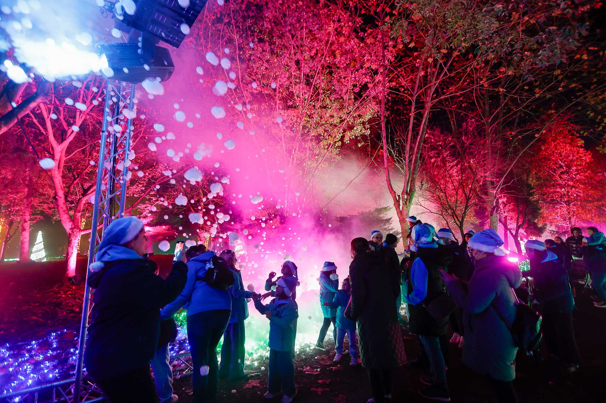 Un grupo de niños juega con burbujas a lo largo del recorrido iluminado.