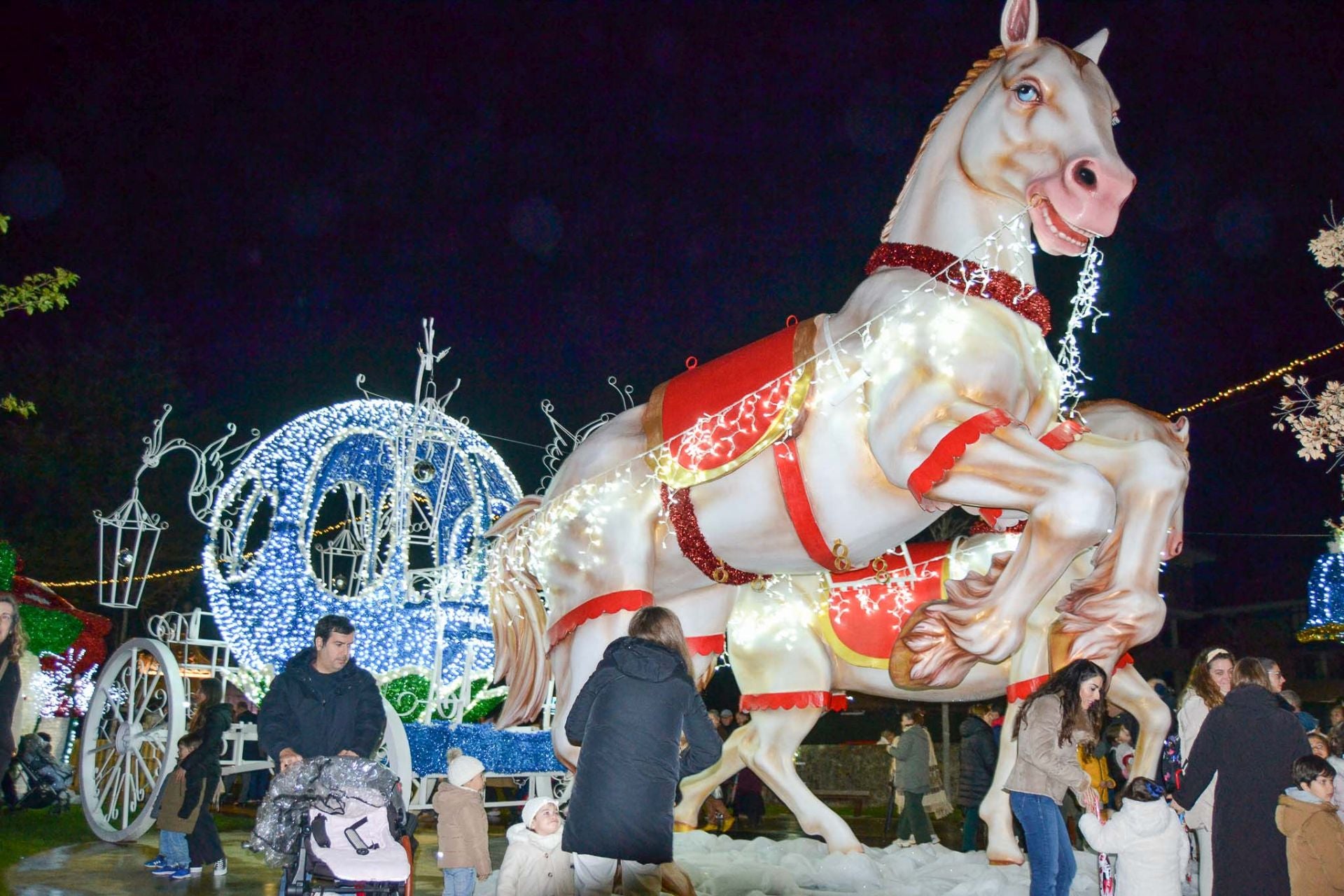 Un mágico carruaje tirado por unos caballo gigantes en el poblado. 