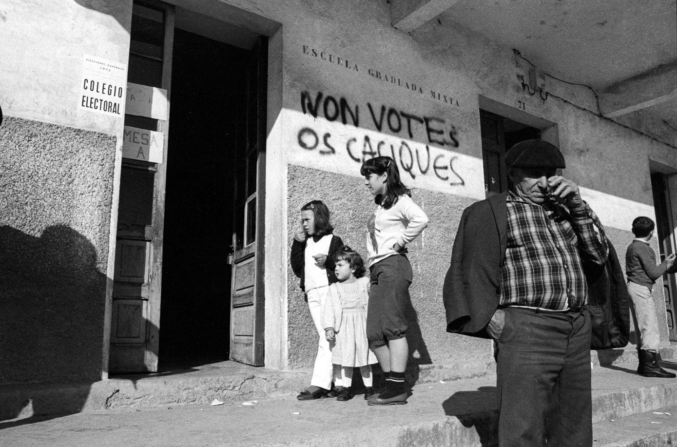 Exterior de un colegio electoral, con el mensaje «Non votes os caciques»