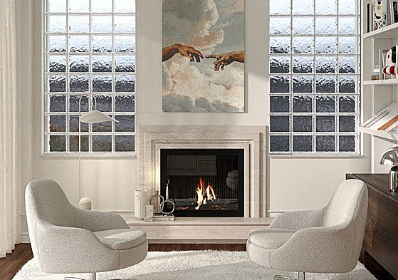 El salón está presidido por una chimenea, dos butacas tapizadas en bouclé, una gran alfombra y una reproducción de 'La creación de Adán', de Miguel Ángel.