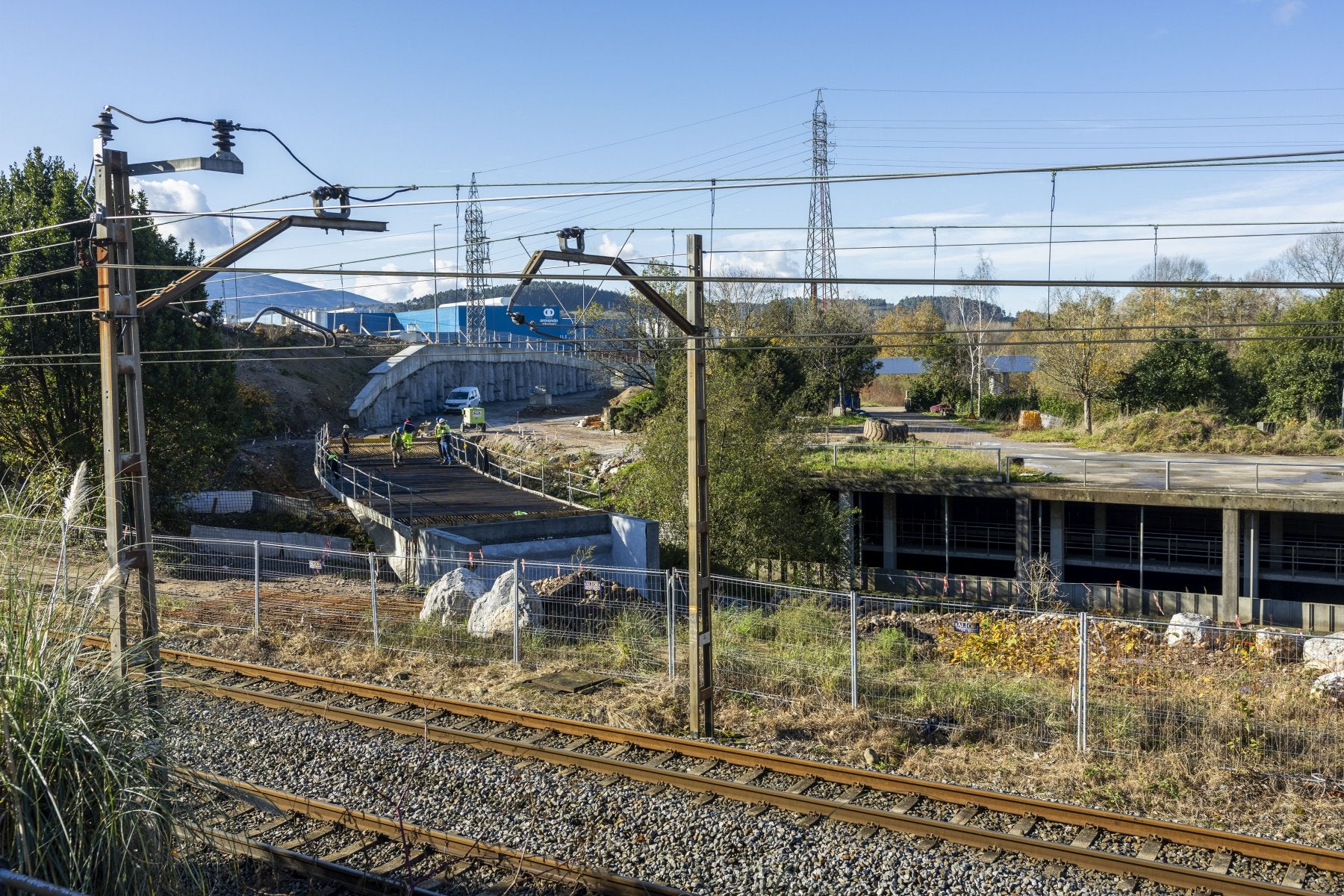 Operarios de la adjudicataria (SIEC) construyen el viaducto sobre el río, el enlace de la vía auxiliar con el trazado original a su paso por Barreda (Torrelavega).