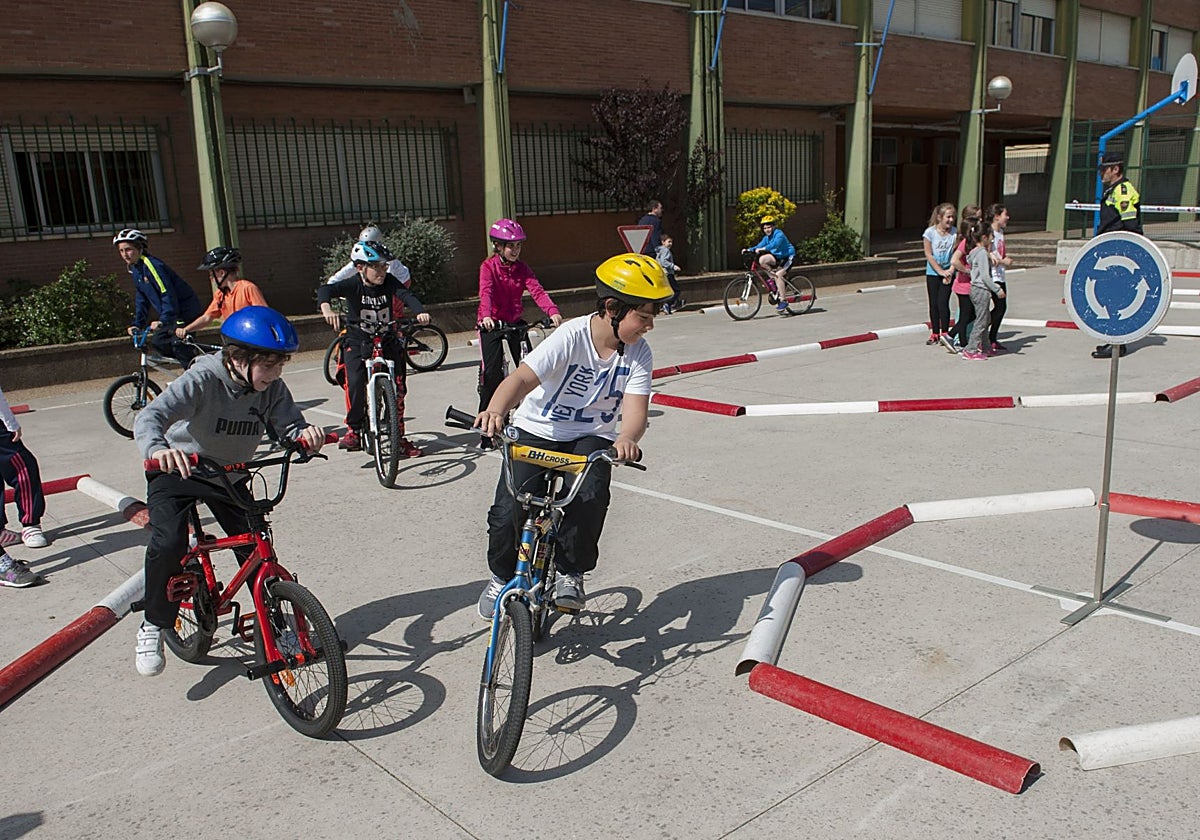 Alumnos realizan una clase de seguridad vial en el patio exterior del centro educativo.