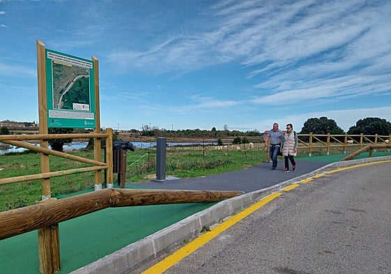 Caminantes transitan por el renovado paseo de Las Traviesas de Noja.
