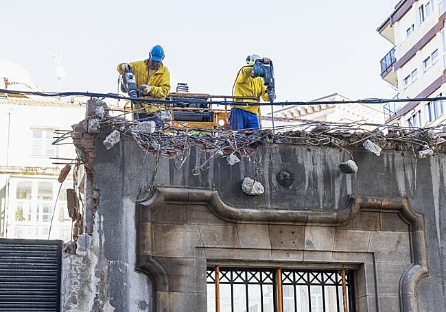 Operarios trabajan en el solar, ya casi limpio de escombros y con solo algunas paredes del inmueble en pie.
