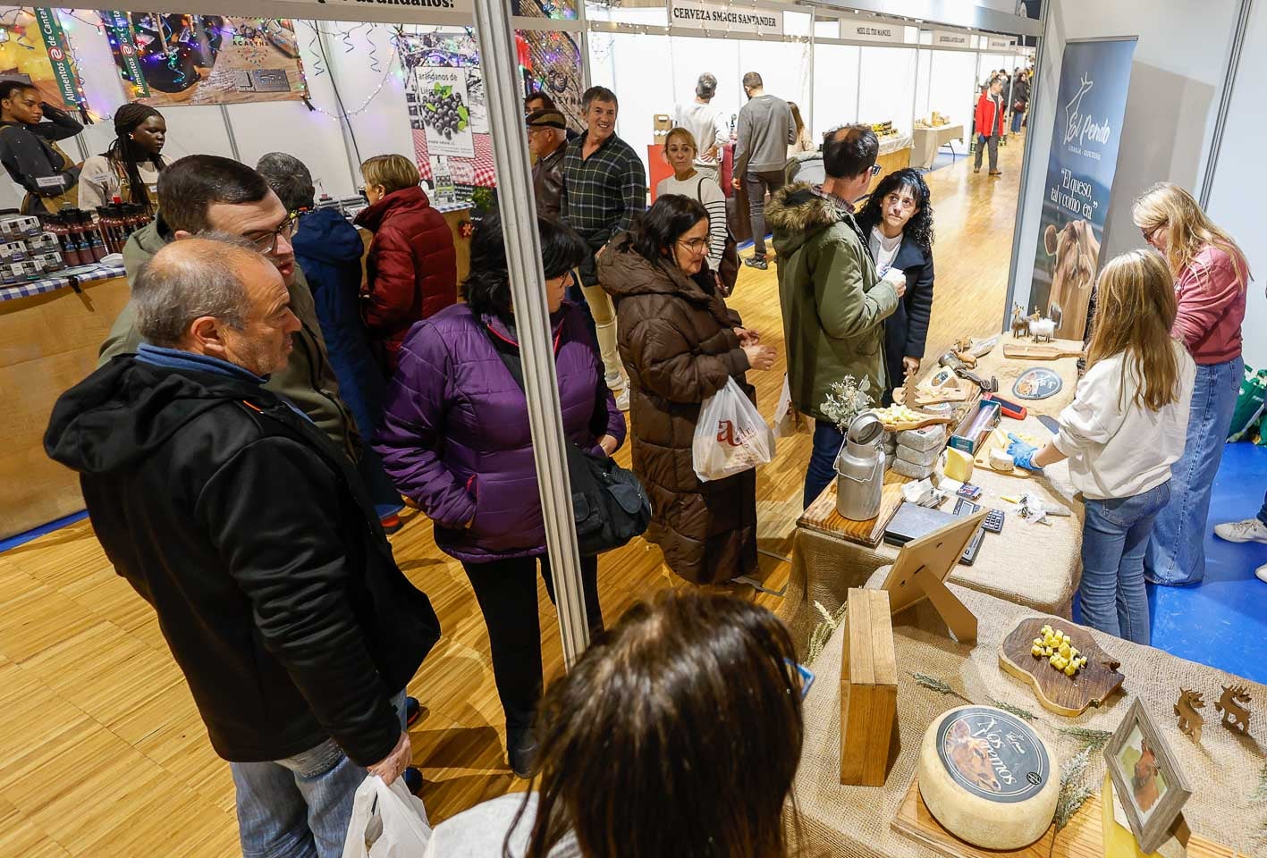 Varias personas contemplan un estand de quesos.