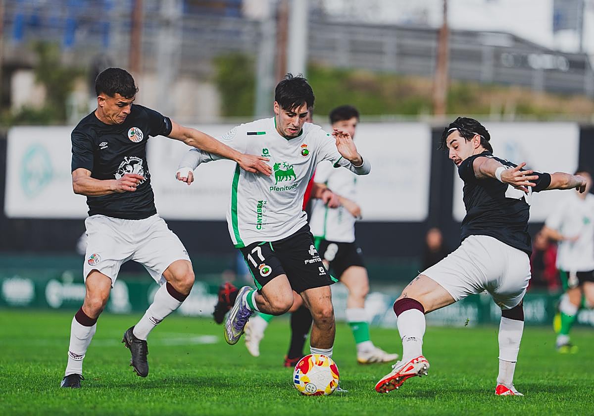 Santi Franco conduce la pelota entre dos rivales.