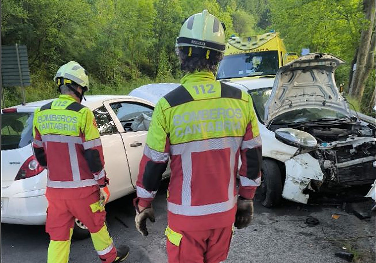 Los bomberos junto a los vehículos implicados en el accidente