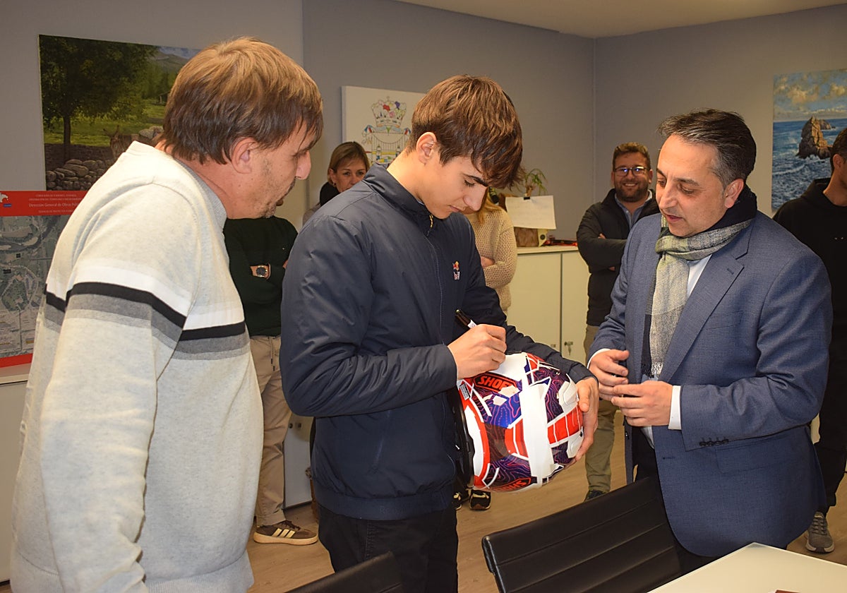 Brian Uriarte le firma un casco al alcalde de Piélagos, Carlos Caramés.
