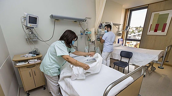Personal sanitario de Valdecilla prepara una habitación en el Edificio 2 de Noviembre.