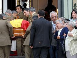 Varios compañeros del brigada asesinado por ETA, introducen el féretro con lsus restos mortales en la Academia de Artillería de Segovia, donde ha quedado instalada la capilla ardiente. / EFE
