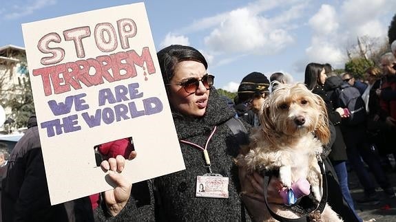 Una mujer sostiene una pancarta en Estambul en la que se puede leer "Detened el terrorismo, somos el mundo". 