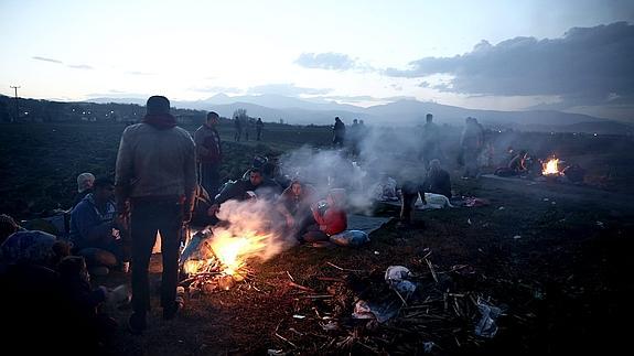 Un grupo de refugiados hacen fogatas para calentarse en un campamento de Idomeni (Grecia).