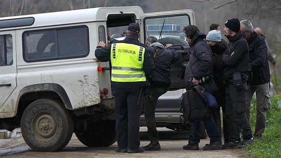 La Policía introduce a varios periodistas en un vehículo.